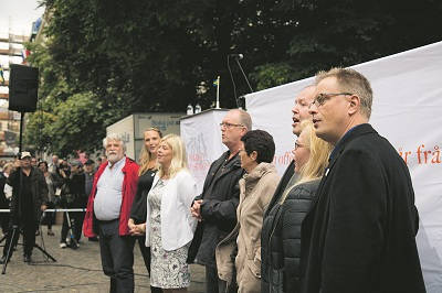 Sjunger nationalsången. Folkets demonstrations talare och arrangörer sjöng tillsammans med demonstrationsdeltagarna. Foto: Nya Tider/Roger Sahlström
